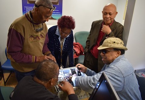 Left to right; Gregory Johnson, Marvin Bailey, Katie Taylor, Udobi Ikeji, and George Hill inspect a computer chassis and motherboard to determine if it can be repurposed for other another use.